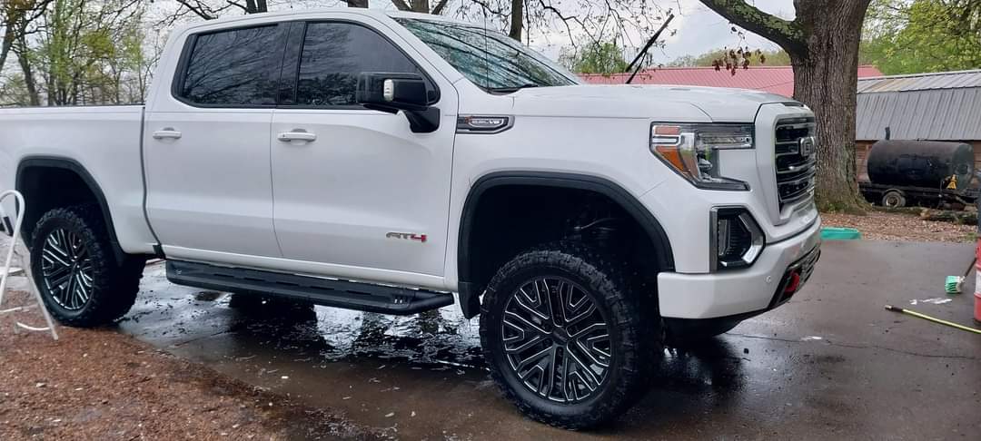 Driver's side view of white 2019 GMC Sierra truck